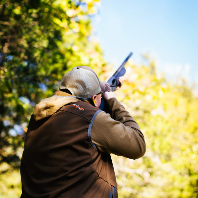 client aiming riffle at skeet shooting course